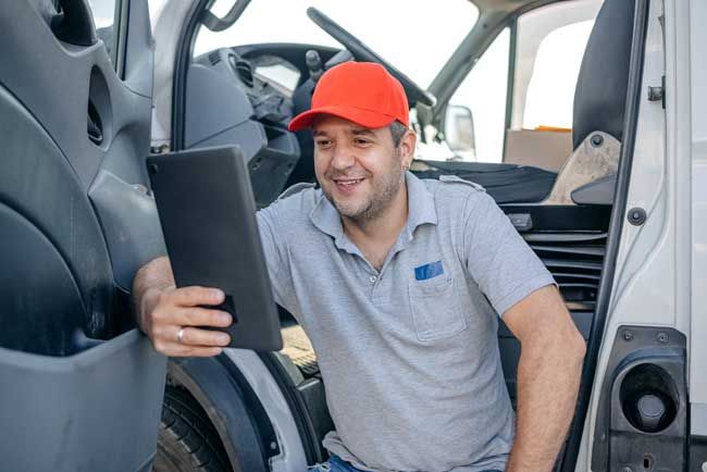 An owner of a fleet of trucks reviews the vehicle usage analytics report provided by his fleet card.